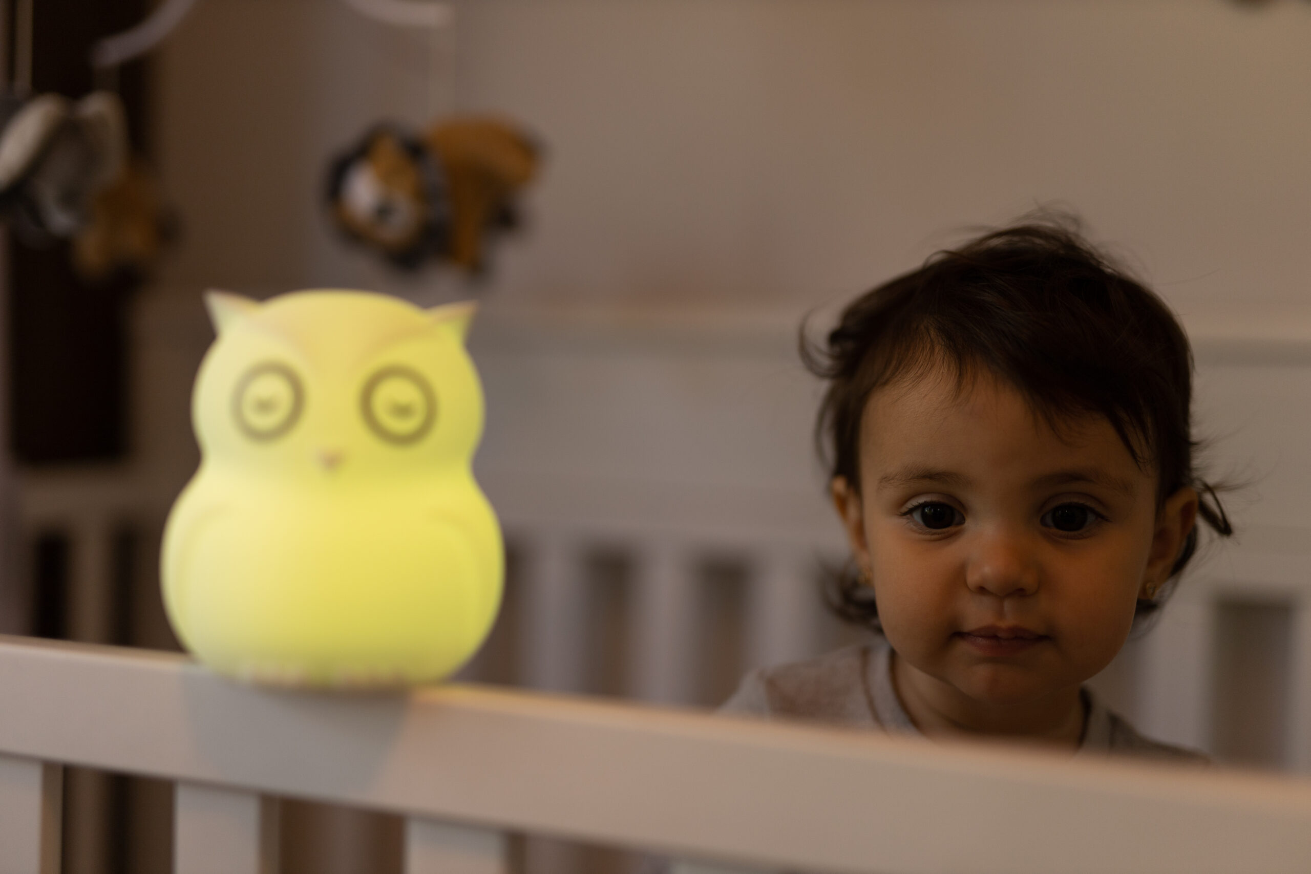 B HIBU Lifestyle Child in bed looking at yellow lighted toy